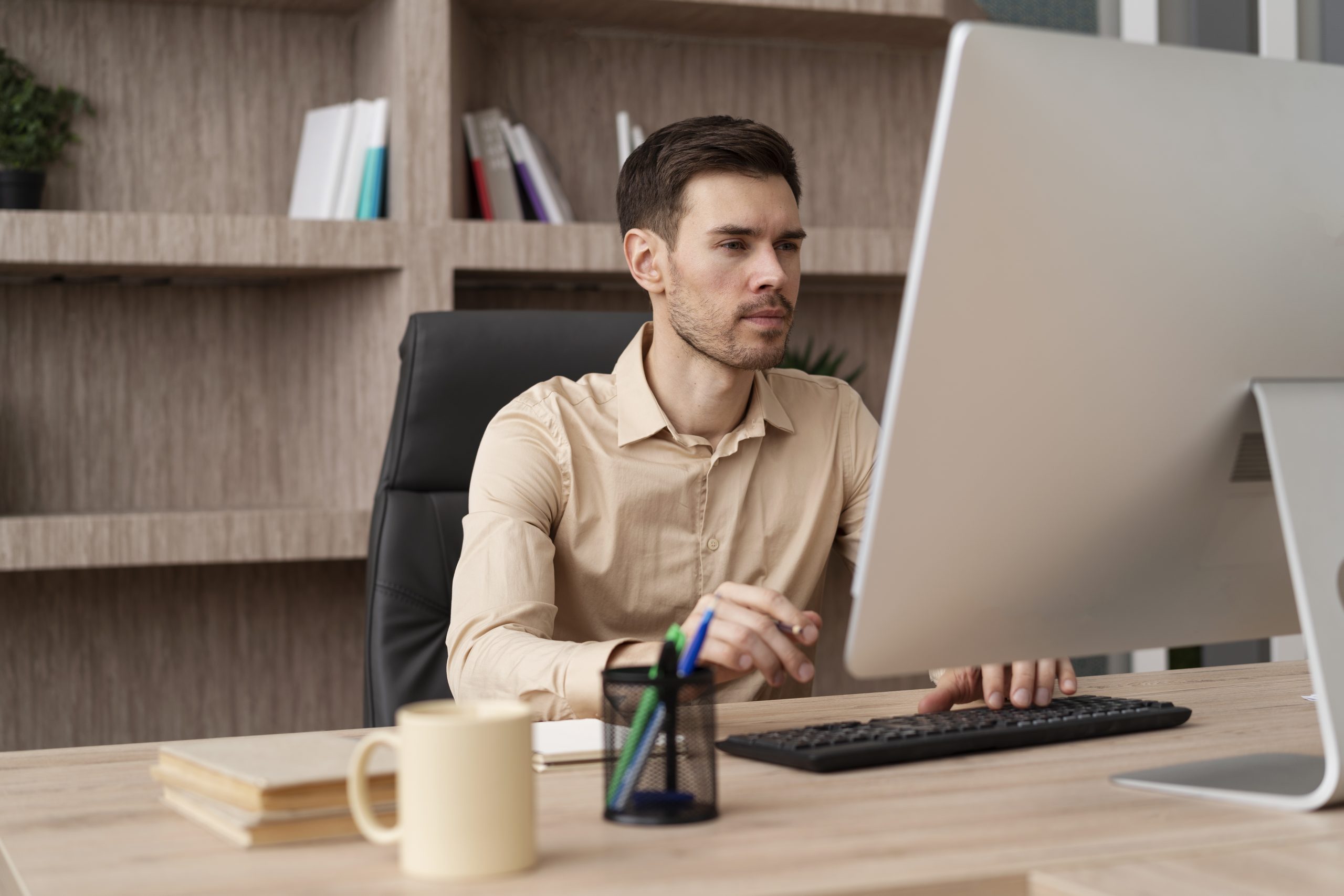 Um homem está sentado em frente ao computador, ele está montando um plano de carreira.