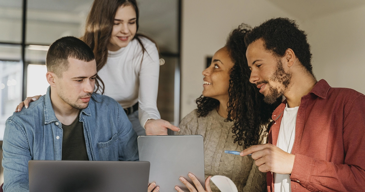 Equipe de RH colaborando em torno de um notebook e tablet para mapear competências pelo Modelo CHA.