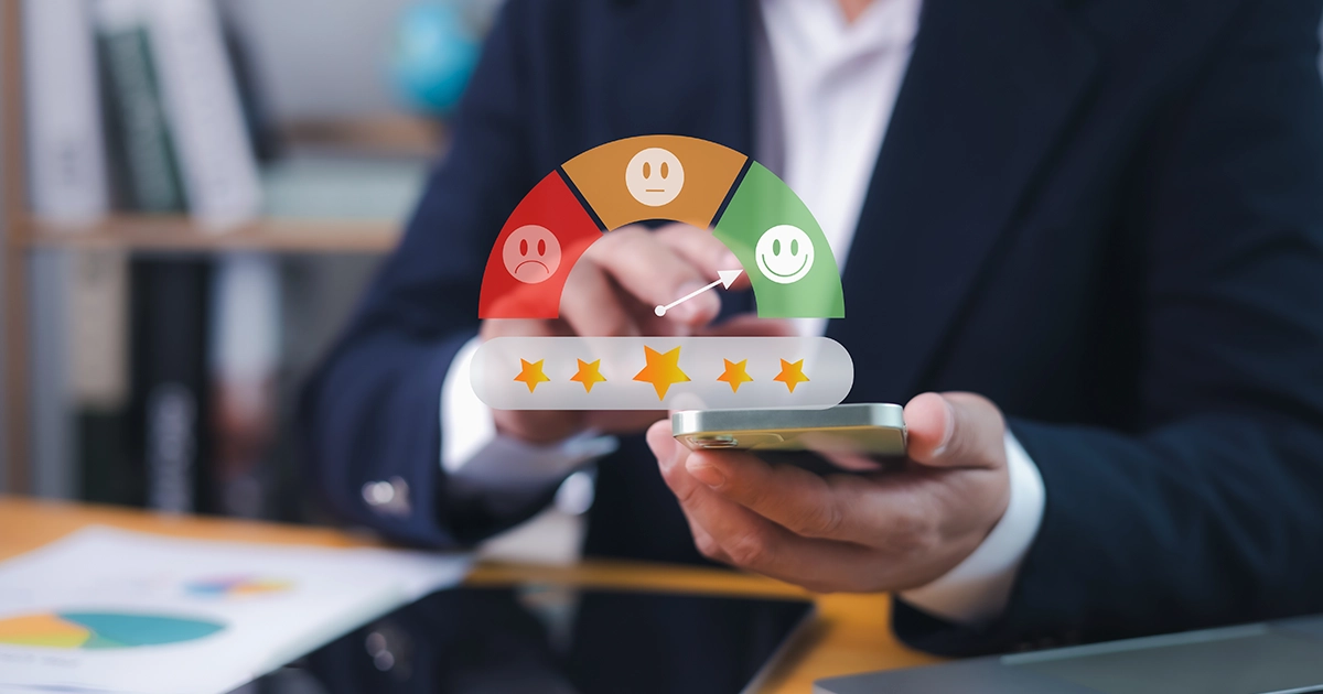 Homem de terno usando smartphone com gráfico digital de nível de satisfação e estrelas, ilustrando a relação entre pdi e avaliação de desempenho