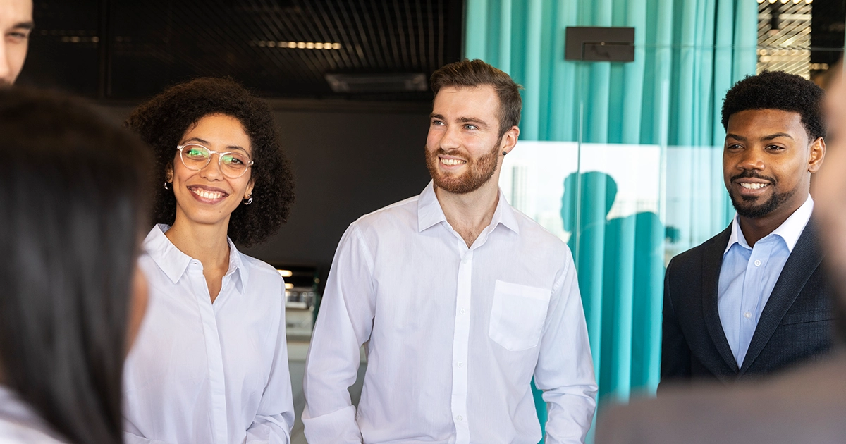 Grupo de profissionais sorridentes reunidos em ambiente corporativo, representando o desenvolvimento de competências através do PDI para líderes
