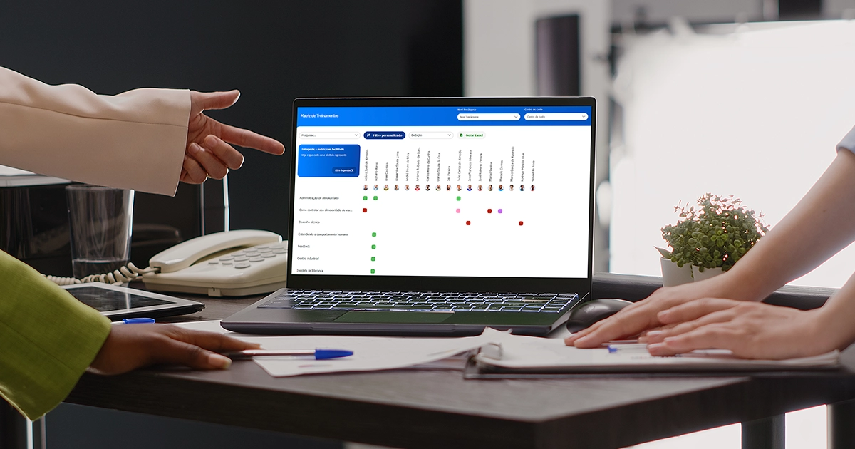 Software de avaliação de desempenho aberto na tela de um notebook enquanto profissionais analisam uma matriz de treinamentos.
