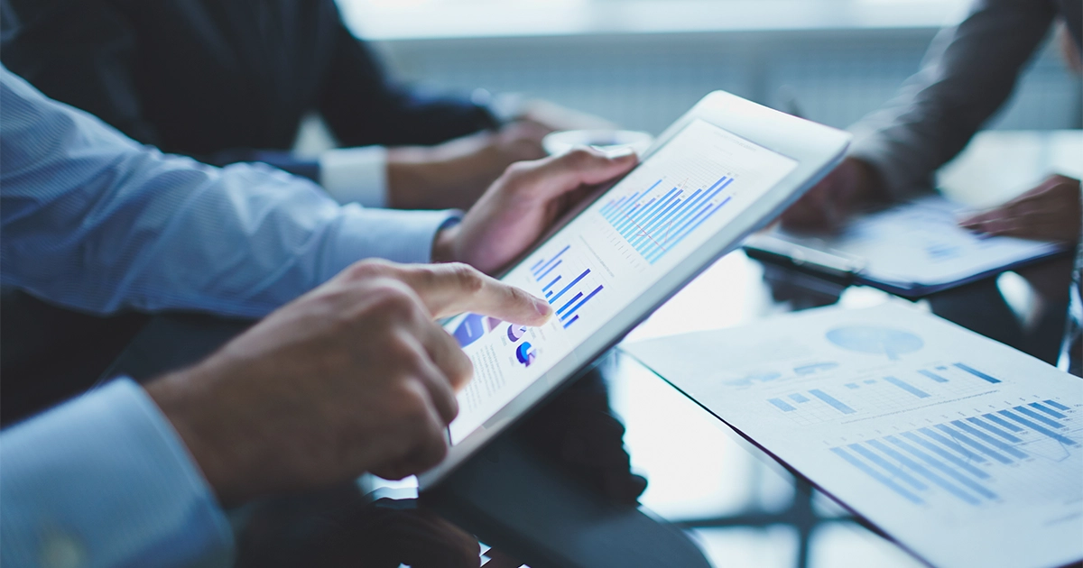 Avaliação de reação: análise de gráficos comerciais em um tablet durante uma reunião corporativa.