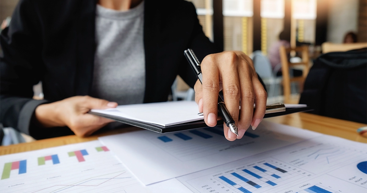Profissional de RH analisando relatórios e gráficos para montar o plano anual de treinamento.