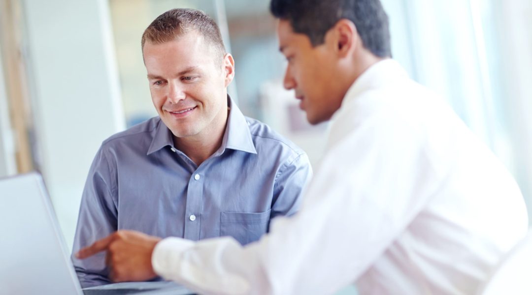 fazendo-um-pdi.jpg O foco da imagem está em um homem loiro, ele está sorrindo enquanto conversa com um homem a sua frente. A imagem representa o momento de alinhamento do pdi