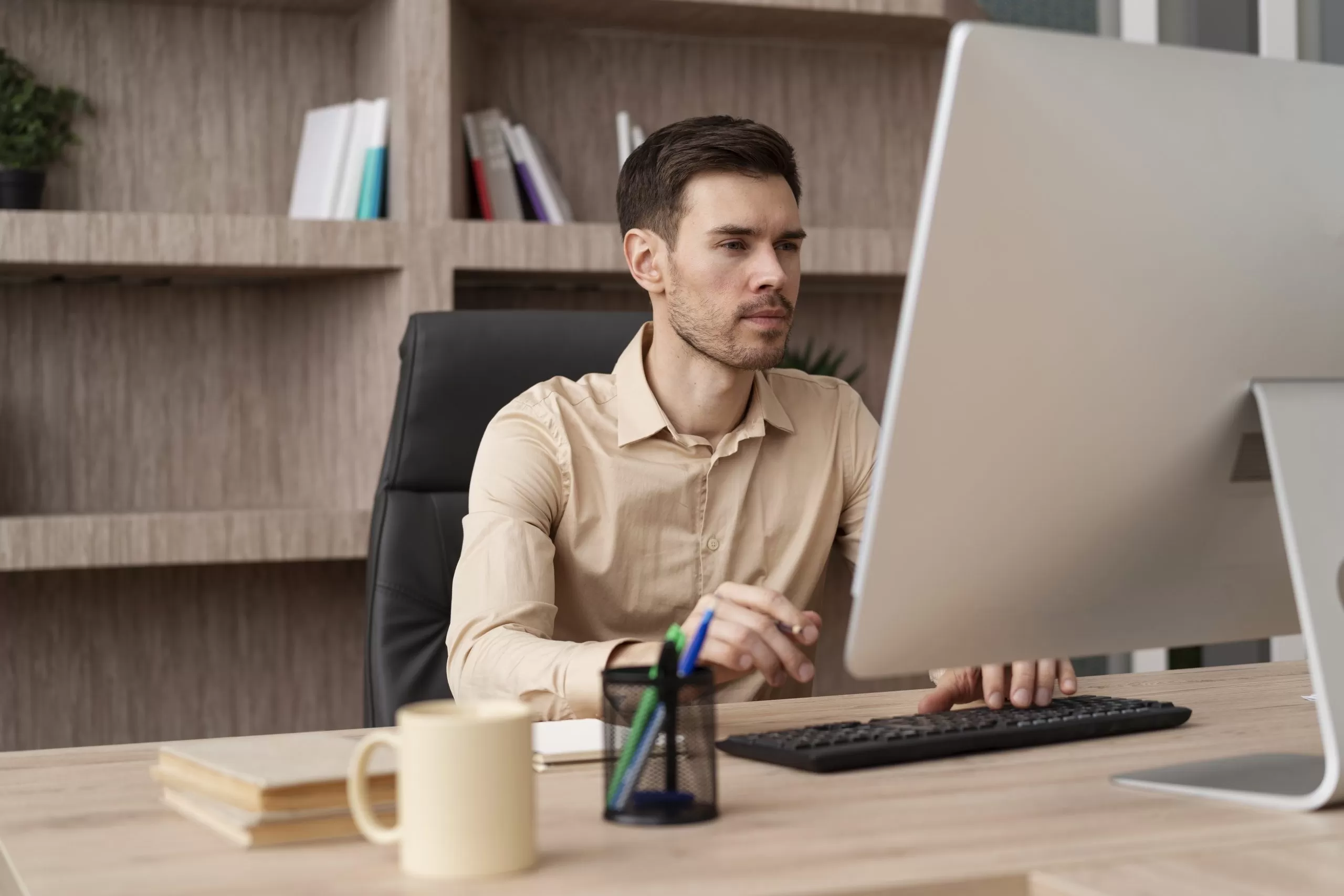 Um homem está sentado em frente ao computador, ele está montando um plano de carreira.