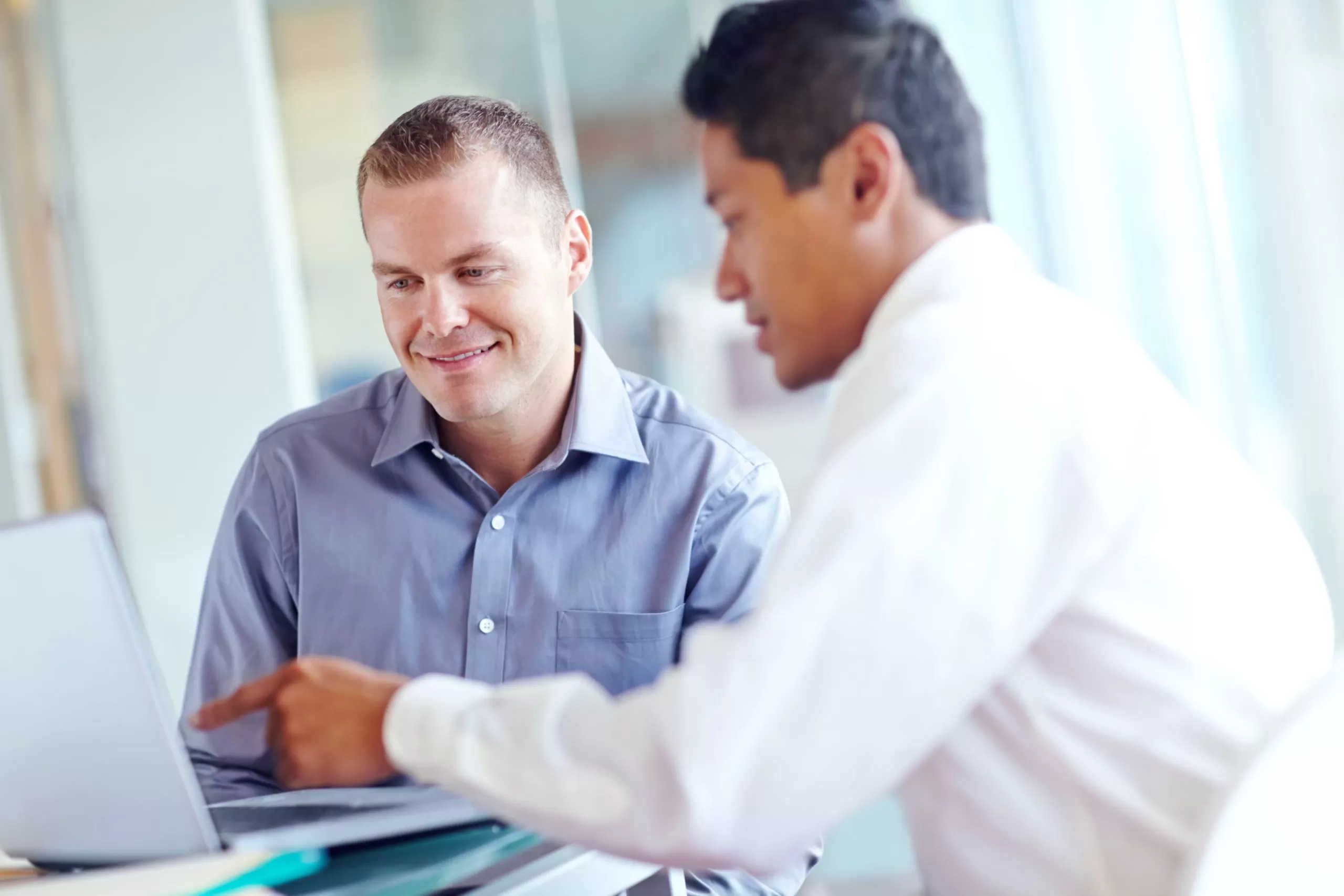 O foco da imagem está em um homem loiro, ele está sorrindo enquanto conversa com um homem a sua frente. A imagem representa o momento de alinhamento do pdi
