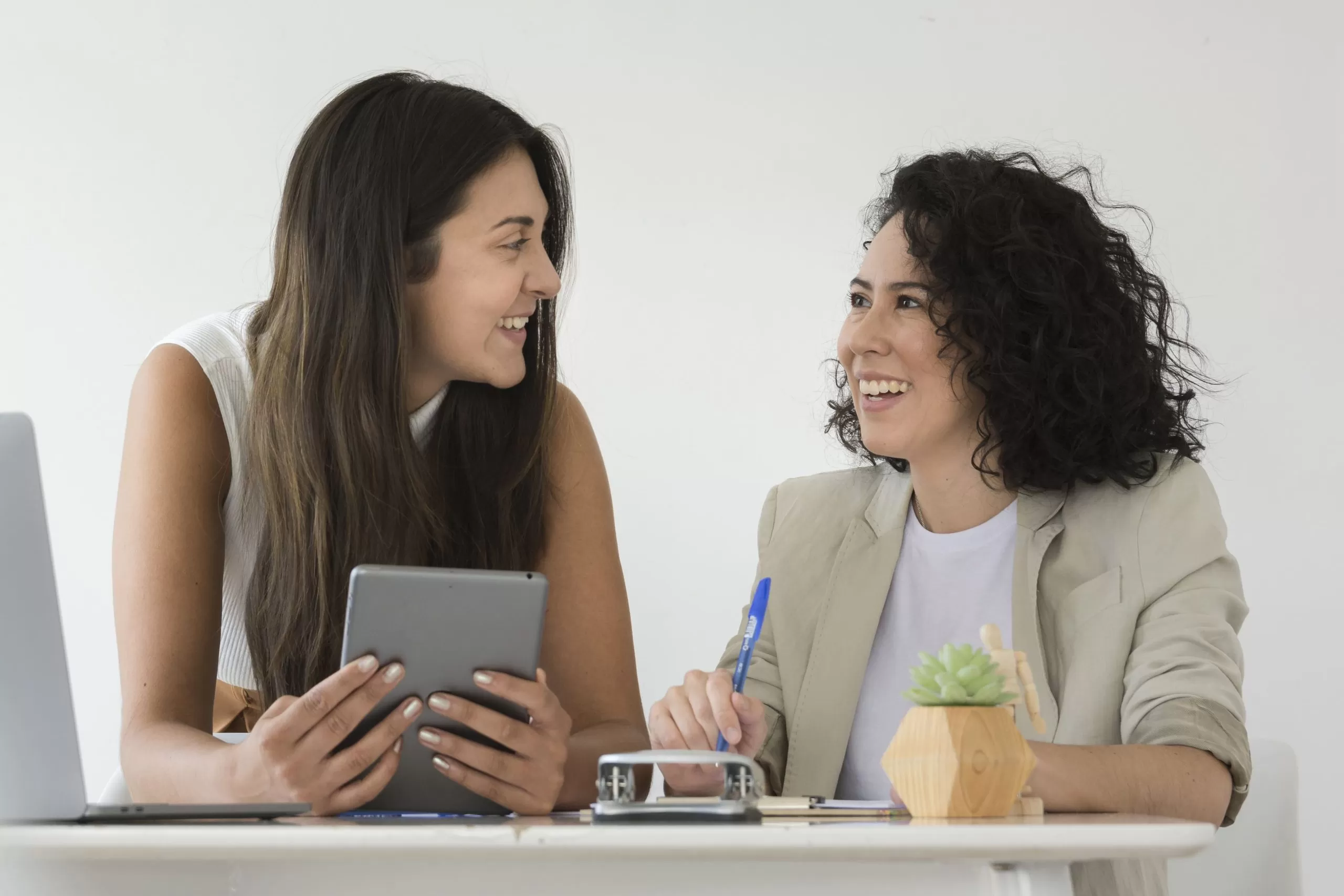 duas mulheres sorrindo finalizando um feedback contínuo